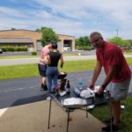 Specialty Plastic Fabricators team member preparing burgers during team cookout